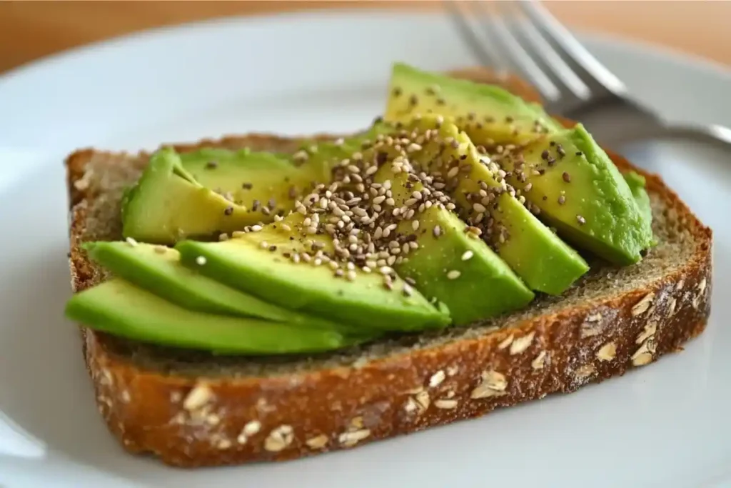 Sourdough toast with avocado and seeds on a white plate.